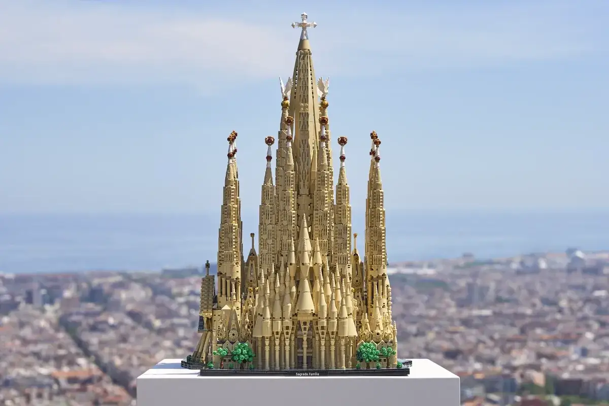 Der detailreiche Lego-Nachbau der Sagrada Familia, ein Lego Set mit den meisten Teilen, thront vor einer verschwommenen Stadtkulisse.