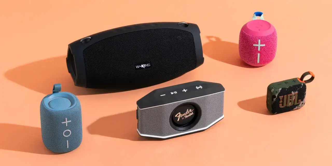 Plusieurs enceintes Bluetooth de diff&eacute;rentes tailles et couleurs sont dispos&eacute;es sur un fond orange. Id&eacute;al pour savoir comment choisir une enceinte Bluetooth.