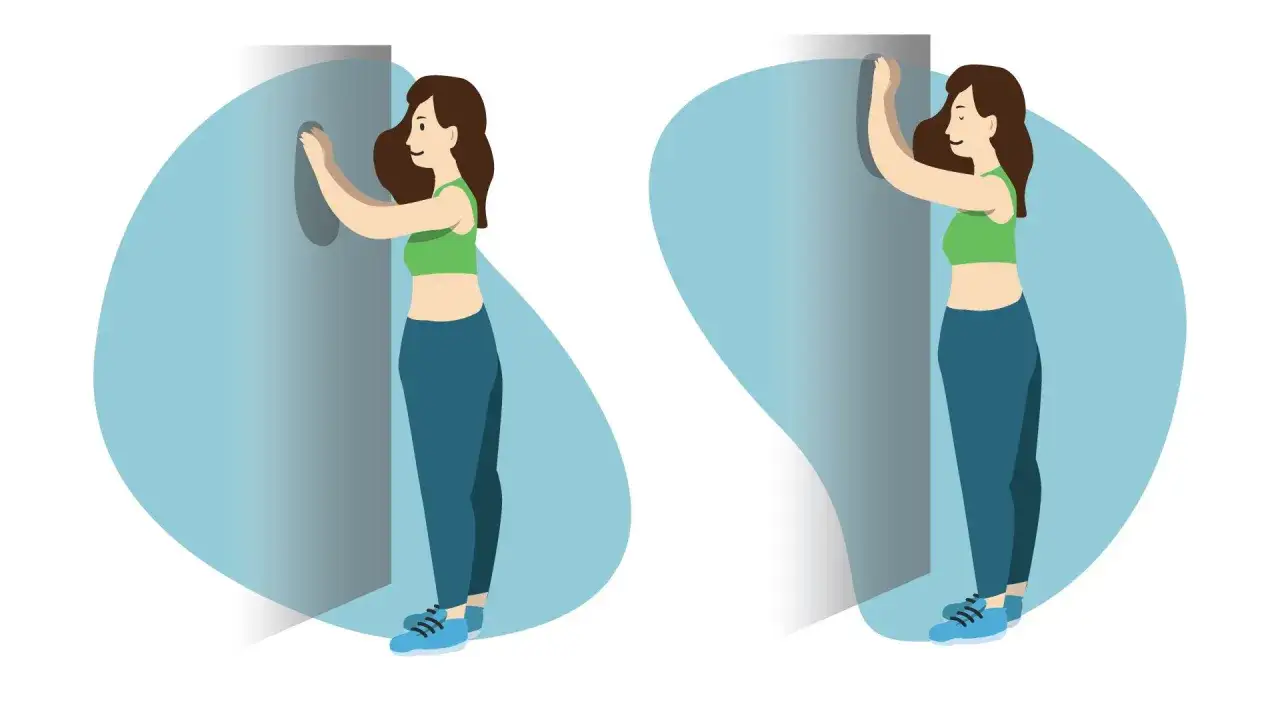Femme faisant des exercices pour le cancer du sein et le sport. Elle se penche contre un mur, bras tendus.