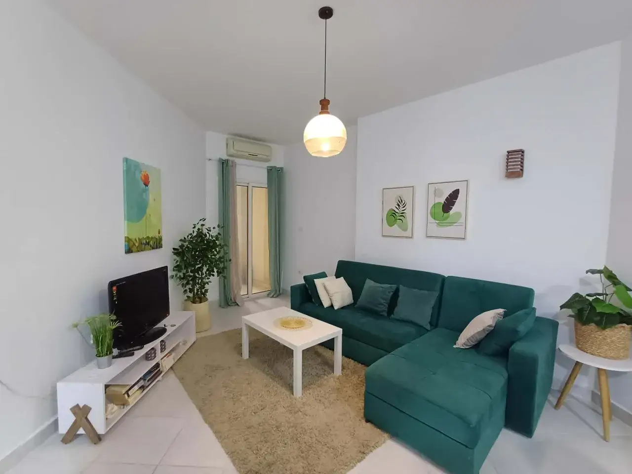 Nowoczesny salon z zieloną kanapą i stolikiem kawowym. Zastanawiasz się, ile kosztuje wynajem mieszkania w Egipcie?