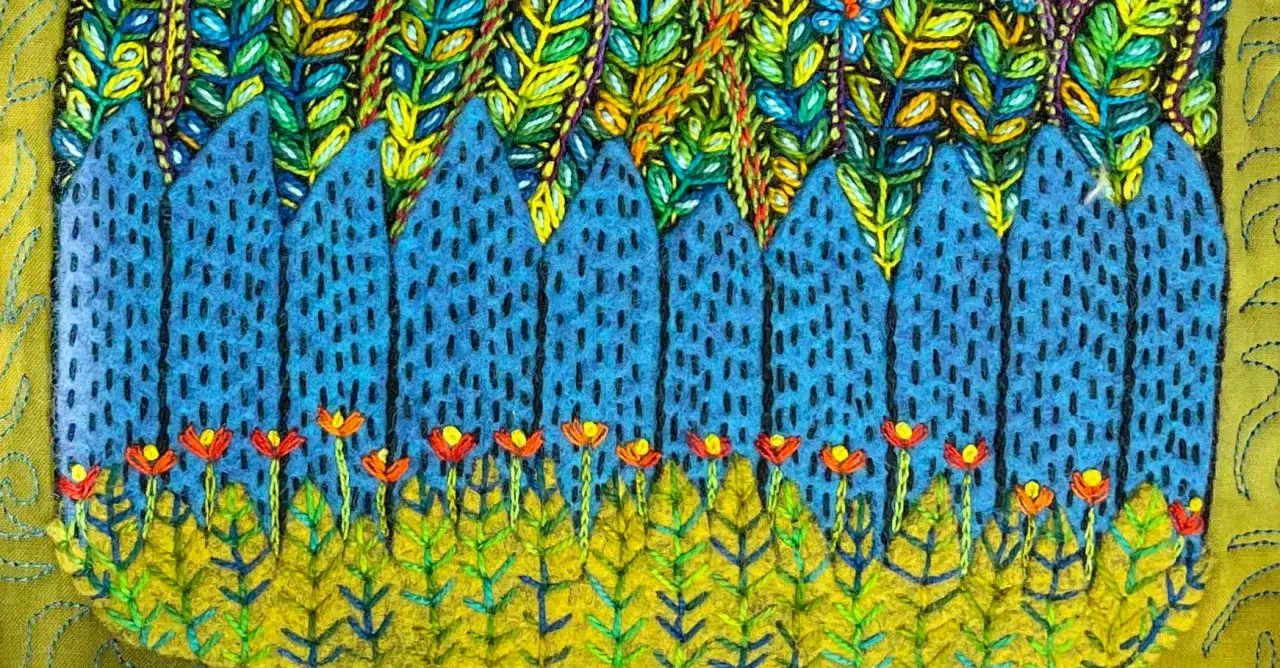 Un paisaje vibrante con un **bordado creativo** de montañas azules, flores rojas y follaje verde y amarillo.
