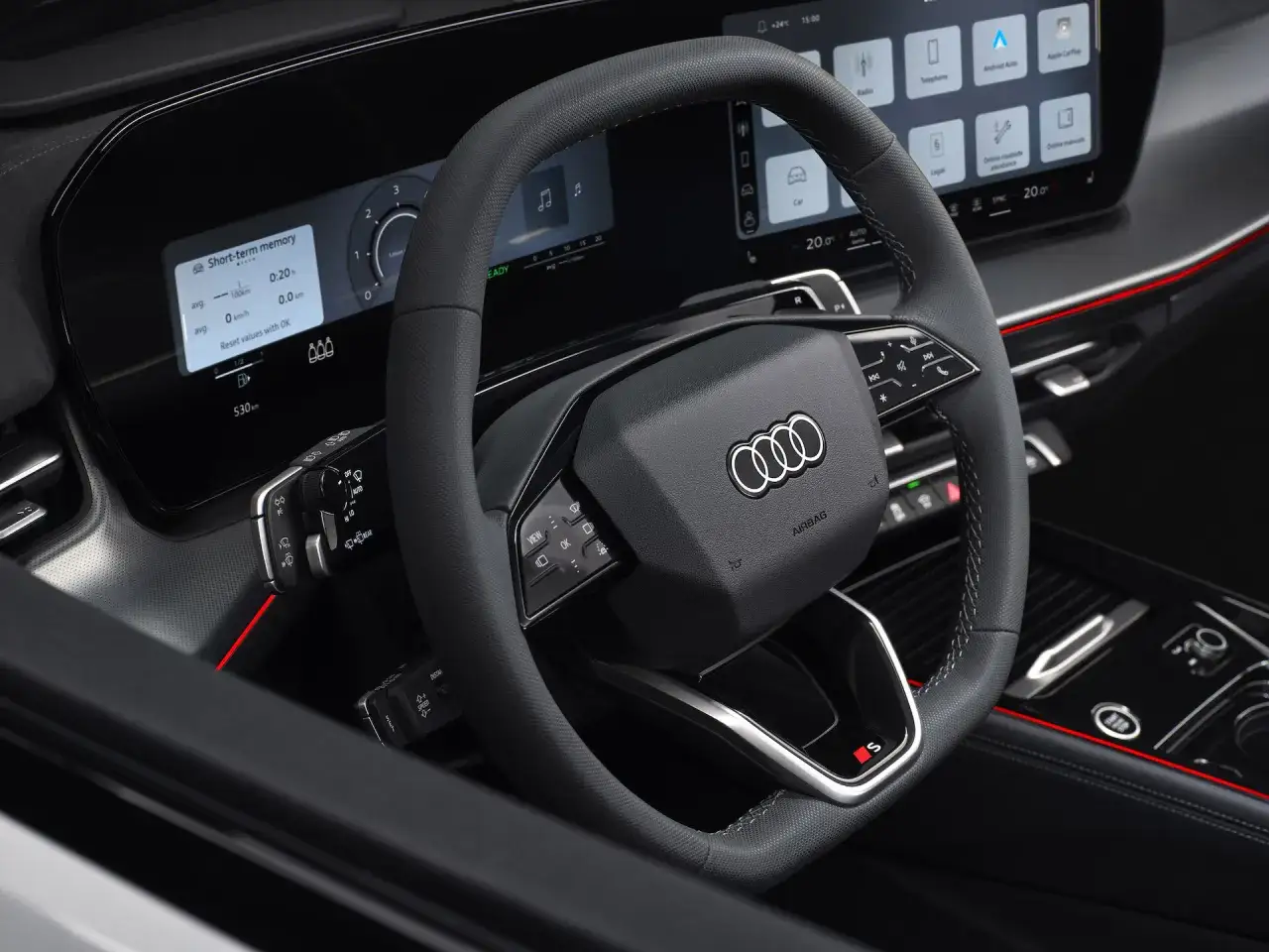 Wnętrze Audi Q3 2025 z kierownicą i ekranem multimedialnym.