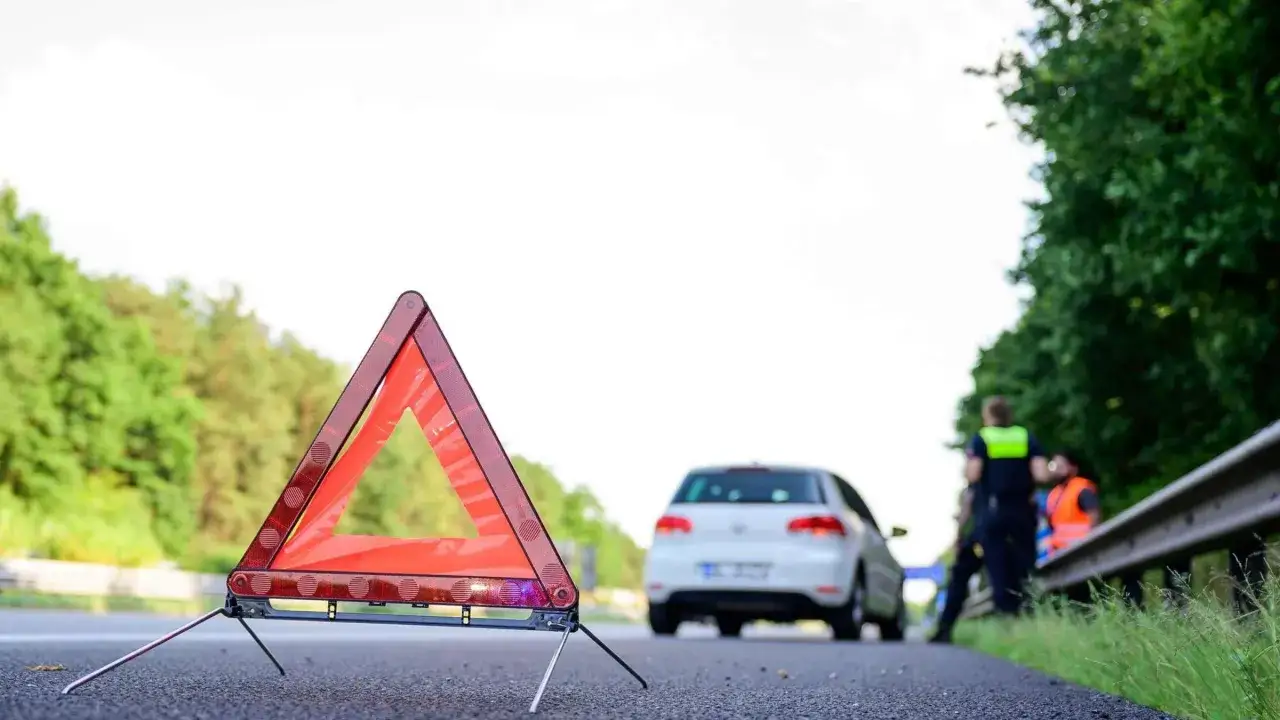 Warndreieck auf der Autobahn. Ihr Fahrzeug ist auf der Autobahn liegen geblieben, Hilfe ist unterwegs.