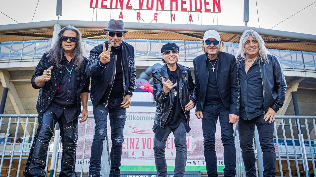Fünf Musiker, darunter Klaus Meine, jung und rockig, posieren vor der Heinz von Heiden Arena.