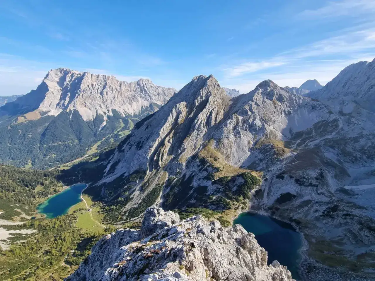 Majest&auml;tische Bergkette mit zwei tiefblauen Seen. Der vordere Drachenkopf ragt imposant empor, umgeben von schroffen Felsen und gr&uuml;nen H&auml;ngen.
