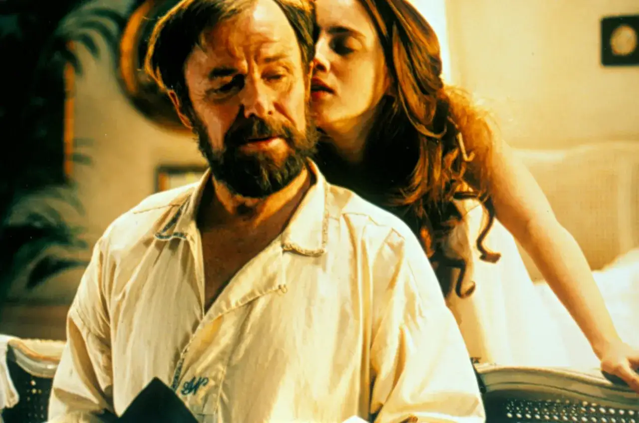 En kvinna viskar i örat på en äldre man med skägg. Scen från en alfred nobel film.
