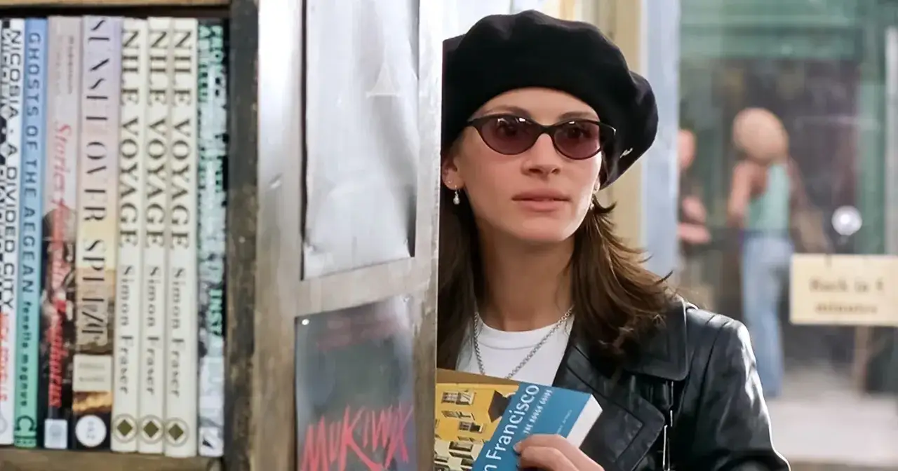 Julia Roberts w czarnej beretce i okularach, z książką w ręku, w scenie z filmu 