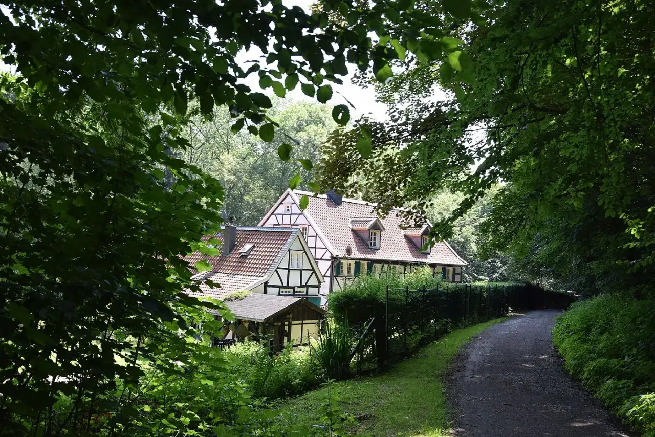 Fachwerkhaus am Wegesrand der korkenziehertrasse Solingen, umgeben von üppigem Grün.