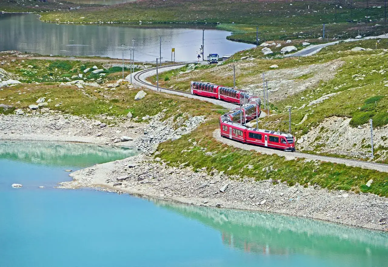 Czerwony pociąg Bernina Express wije się po górskiej trasie. Poznaj trasę i ceny tej malowniczej podróży.