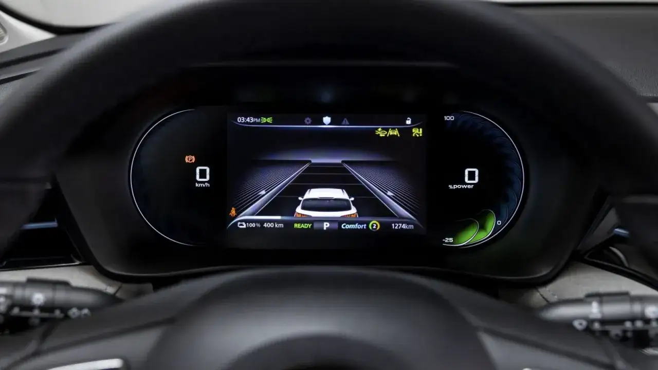Schermo digitale auto: vista dall'alto di una corsia con un'auto bianca al centro. Indicatore di velocit&agrave;, autonomia e modalit&agrave; 