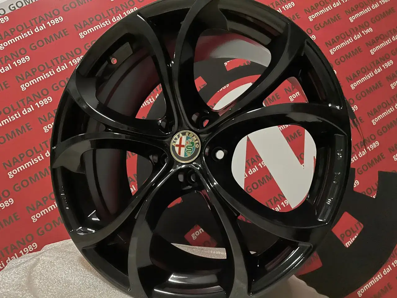 Cerchi Stelvio 20 pollici neri lucidi con logo Alfa Romeo al centro.