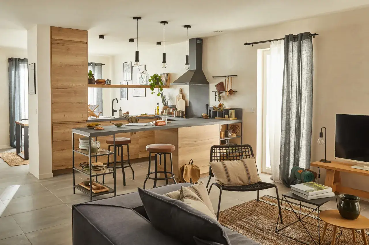 Cuisine et salon ouverts, ambiance chaleureuse avec bois clair et touches naturelles. Une belle idee deco nature pour un int&eacute;rieur cosy.