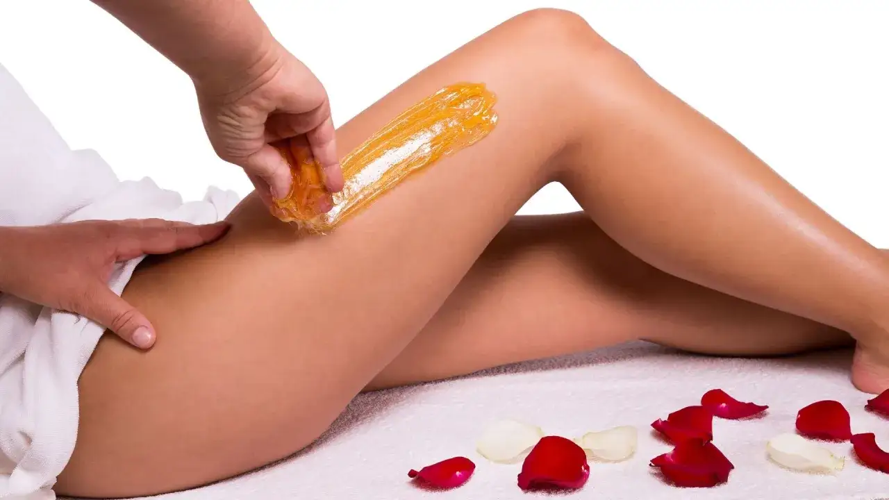 Kobieta wykonująca peeling i nawilżanie nóg po depilacji woskiem