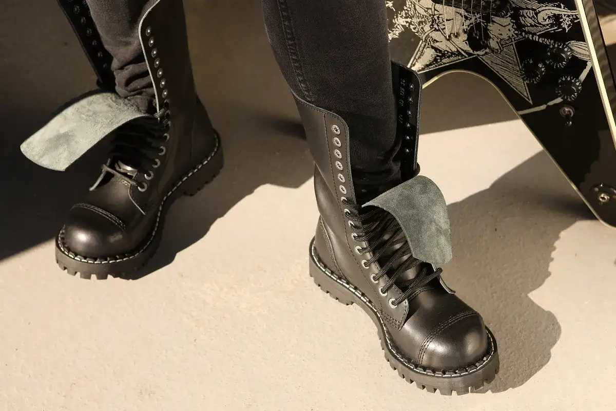 Czarne, wysokie buty glany z grubą podeszwą. Zastanawiasz się, dlaczego buty skrzypią? Może to kwestia nowej skóry lub podeszwy.