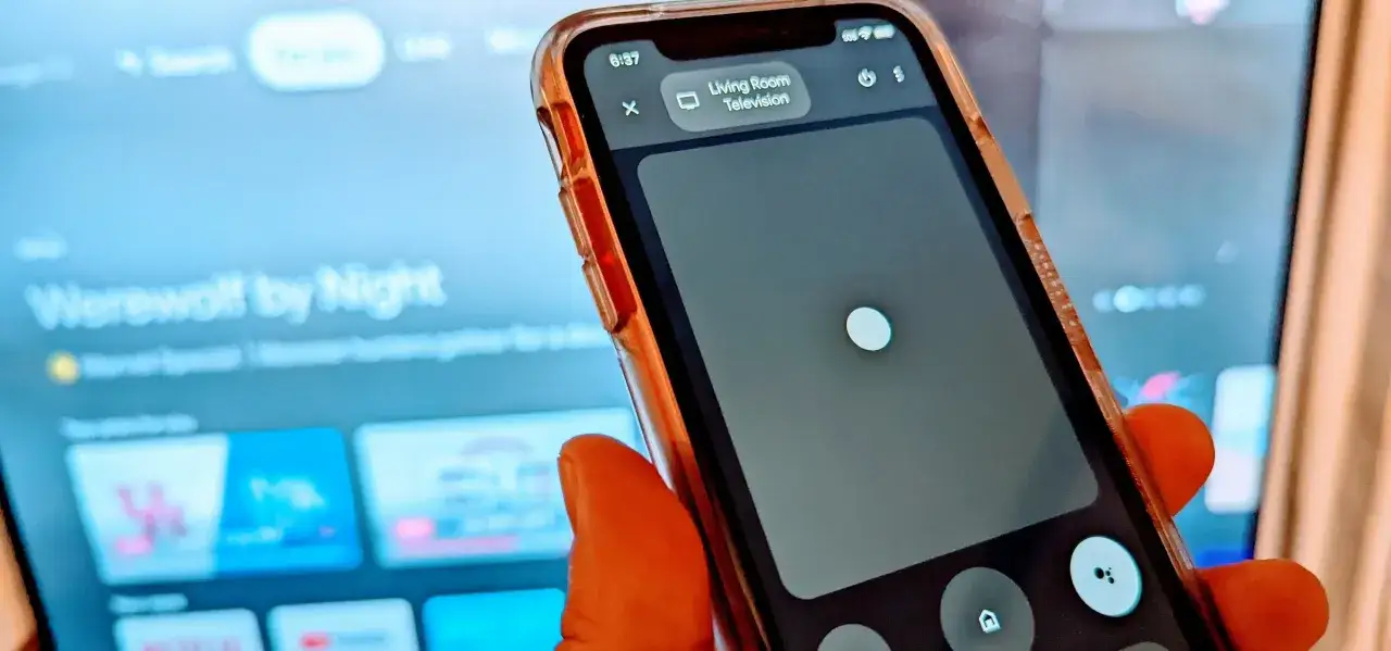 Smartfon z aplikacją pilot do telewizora steruje ekranem, na którym widać tytuł