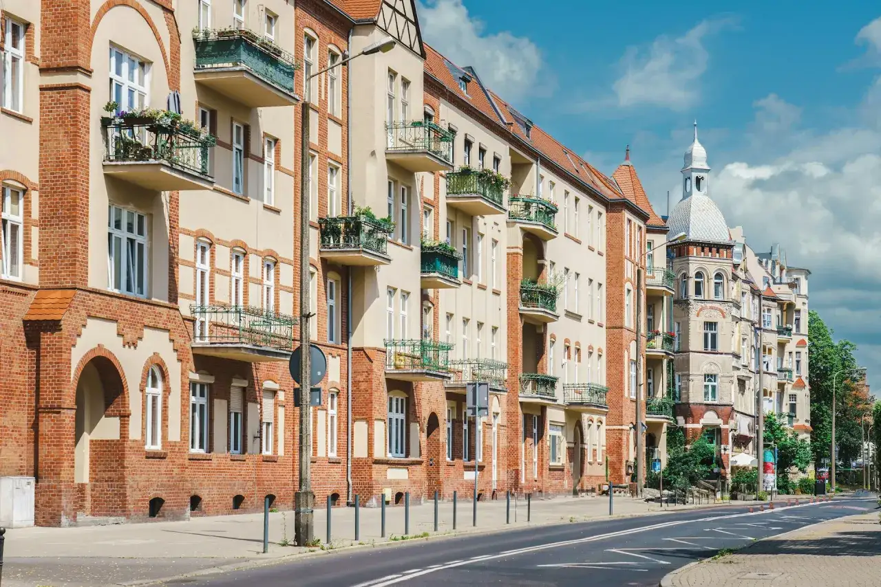 Kamienice z balkonami i wieżyczką, przypominające o przepisach dla małej wspólnoty mieszkaniowej.