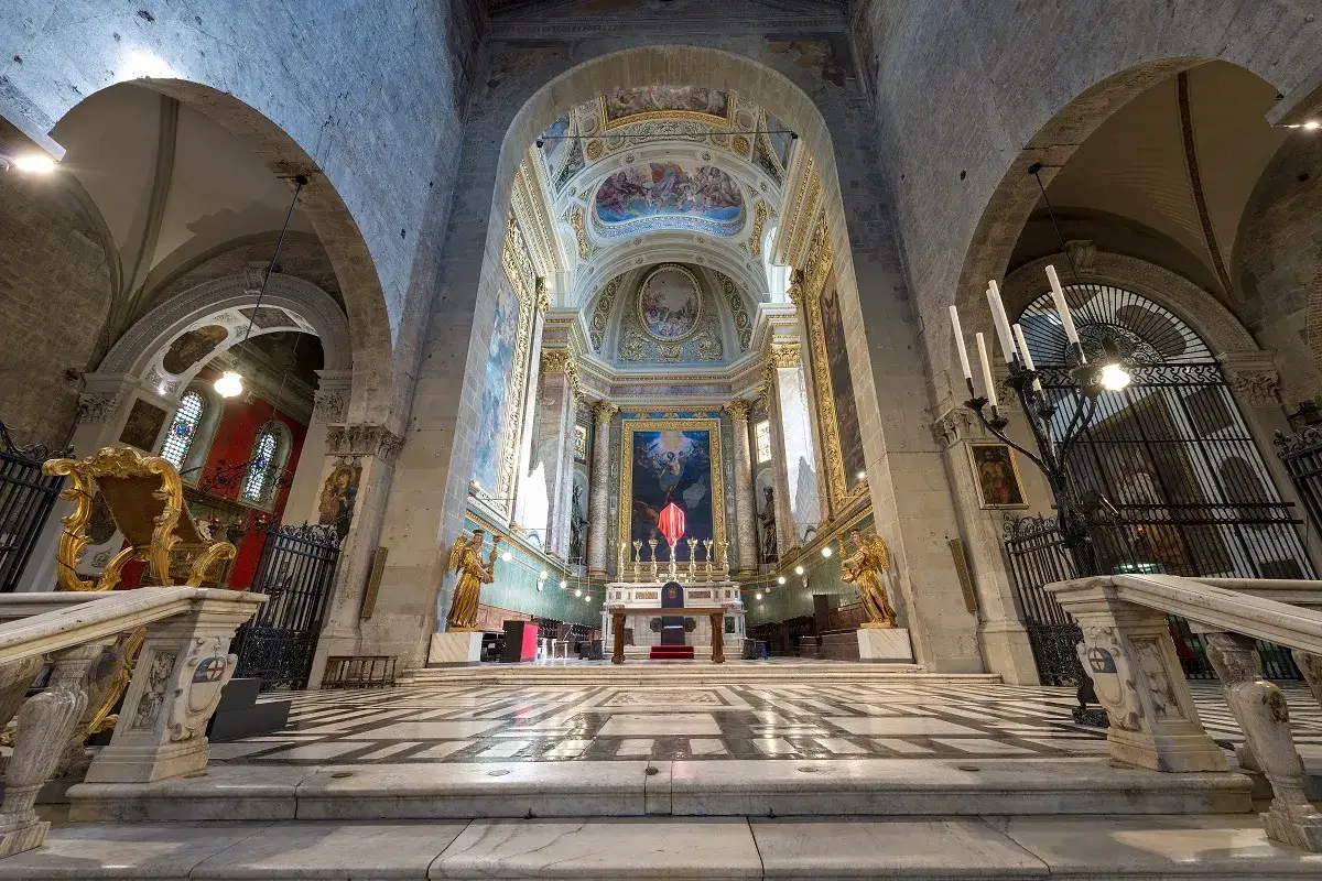 Interno della cattedrale di San Zeno, con l'altare maggiore, affreschi e statue dorate.