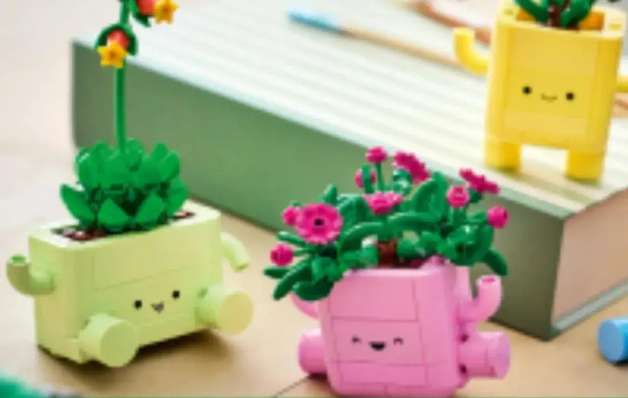 Drei fr&ouml;hliche Pflanzen aus LEGO-Steinen in bunten T&ouml;pfen mit Gesichtern. Sie sehen aus, als w&uuml;rden sie sich &uuml;ber das Wachstum freuen.