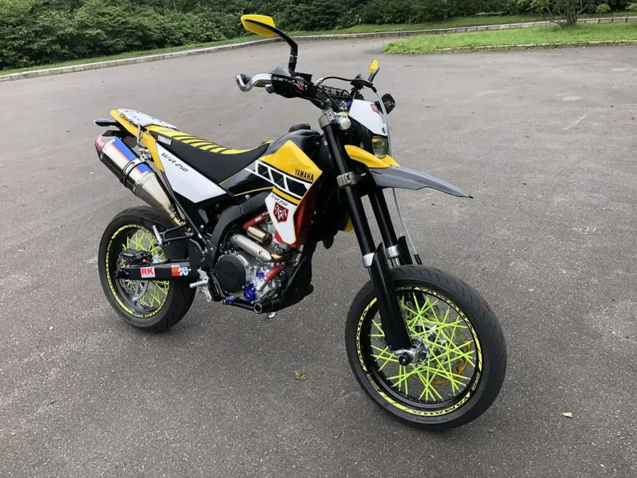 Yamaha WR 250 X personalizada con rines de radios verdes brillantes y escape azul. Lista para la aventura.