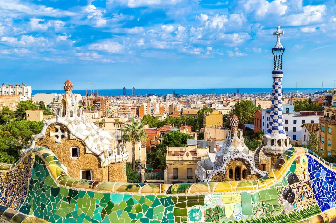 Kolorowe mozaiki Parku Güell w Barcelonie, stolicy Katalonii, z widokiem na miasto i morze.