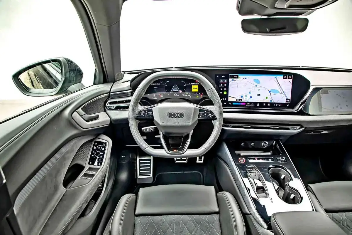 Wnętrze Audi A5 2025: nowoczesny kokpit z dużym ekranem nawigacji i wirtualnymi zegarami.