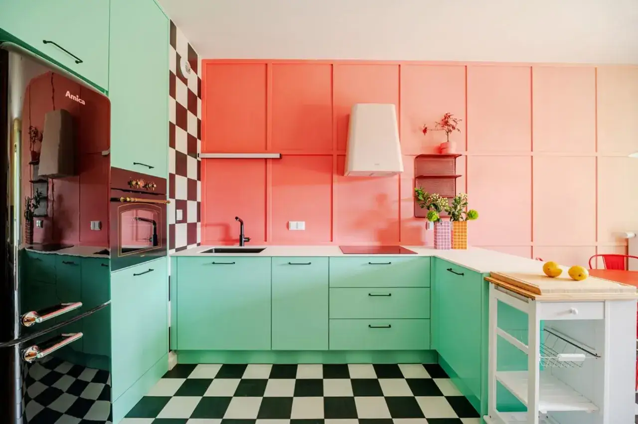 Kolorowa kuchnia w stylu retro z miętowymi szafkami, szachownicą i koralowymi ścianami. Inspiracje dla odważnych aranżacji.
