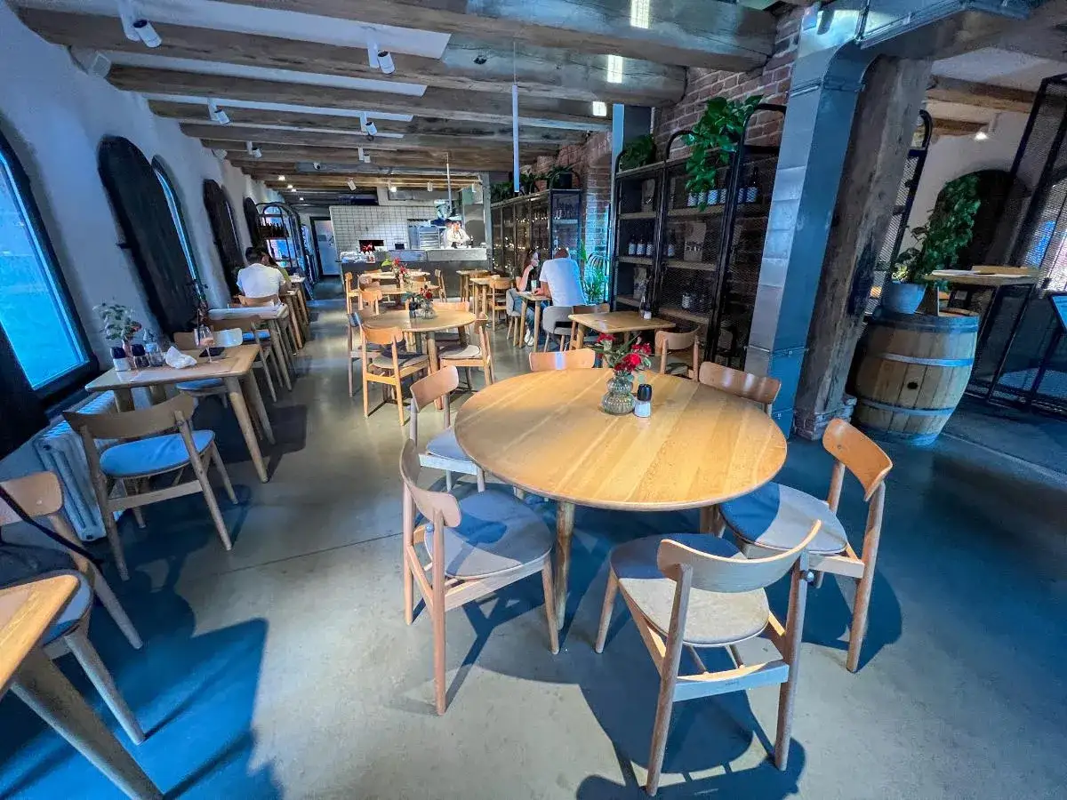Przytulna restauracja w Toruniu, idealne miejsce, gdzie zjeść. Drewniane stoły i krzesła tworzą ciepłą atmosferę.