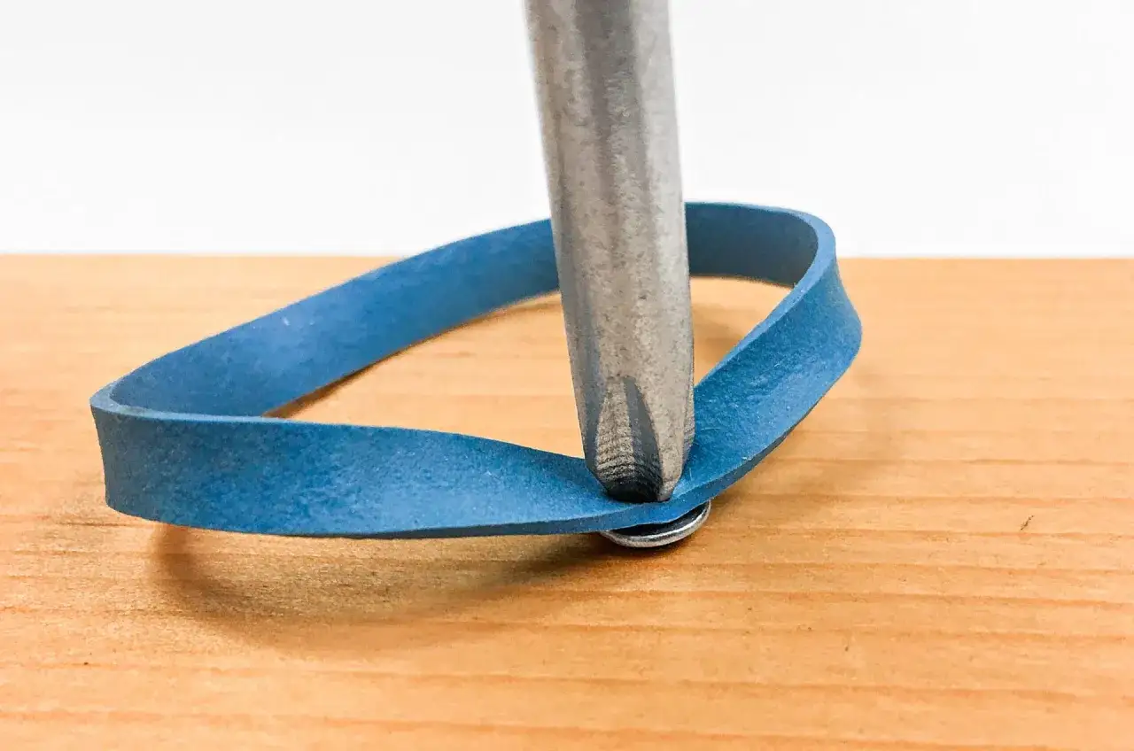 Tornillo pasado de rosca en metal: truco para quitarlo con goma elástica y destornillador.