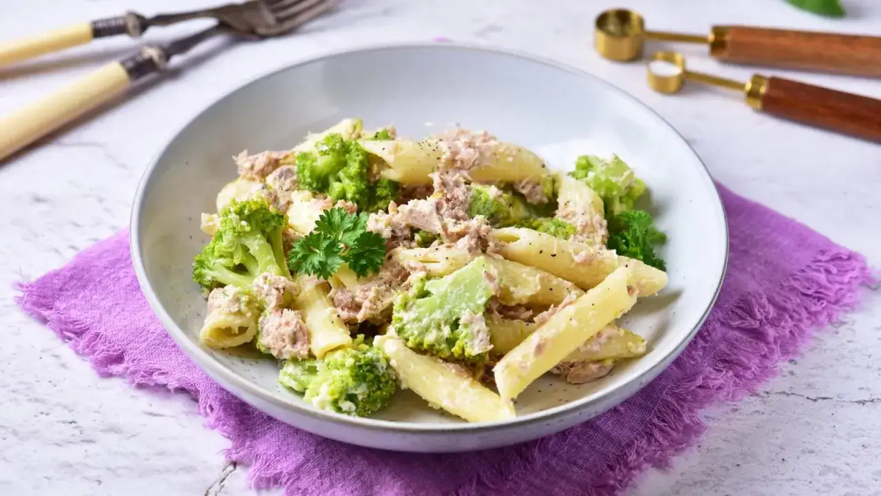 Penne z tuńczykiem i brokułami w kremowym sosie śmietanowo-serowym, posypane pieprzem. Pyszne danie na szybki obiad.