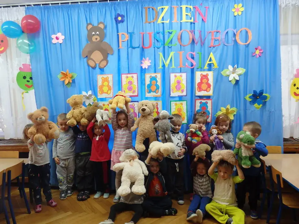 Dzieci świętujące Dzień Pluszowego Misia w przedszkolu lub szkole