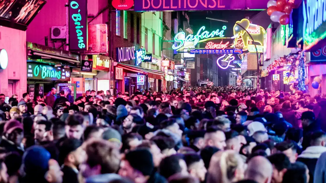 Bunte Lichter und eine Menschenmenge auf der Reeperbahn. Nina genie&szlig;t die Nacht.