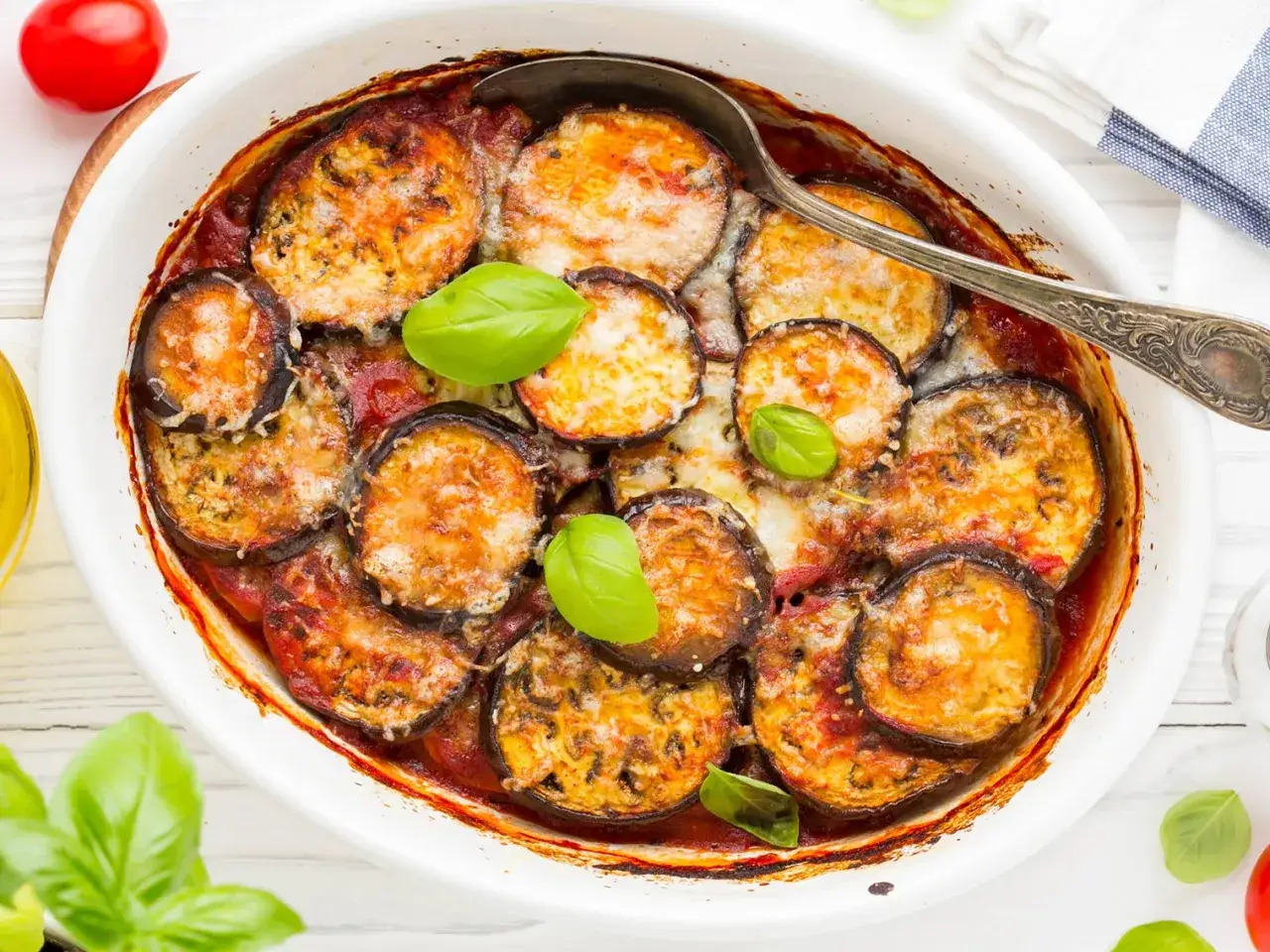Un plat de moussaka rapide, gratin&eacute; et savoureux, avec des aubergines, de la sauce tomate et du fromage fondant, garni de feuilles de basilic frais.