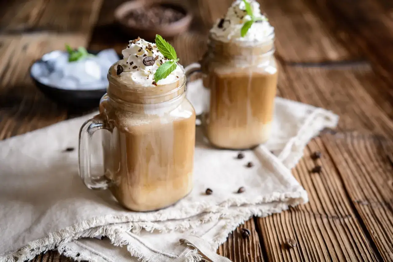 Zwei Gläser Eiskaffee mit Sahne und Minze, perfekt zum Eiskaffee selber machen.