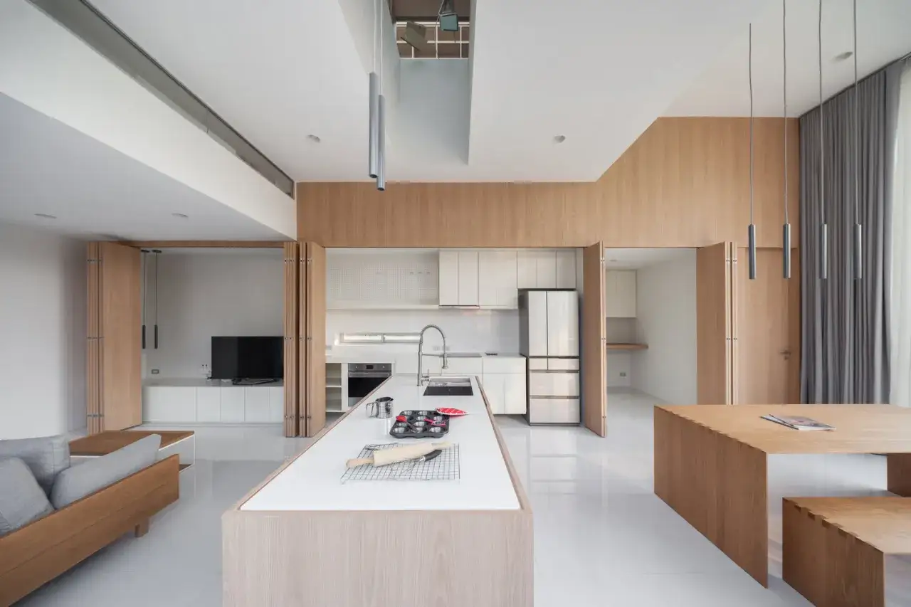 Cocinas invisibles se esconden tras puertas plegables de madera. Un dise&ntilde;o moderno y minimalista con isla central y electrodom&eacute;sticos integrados.