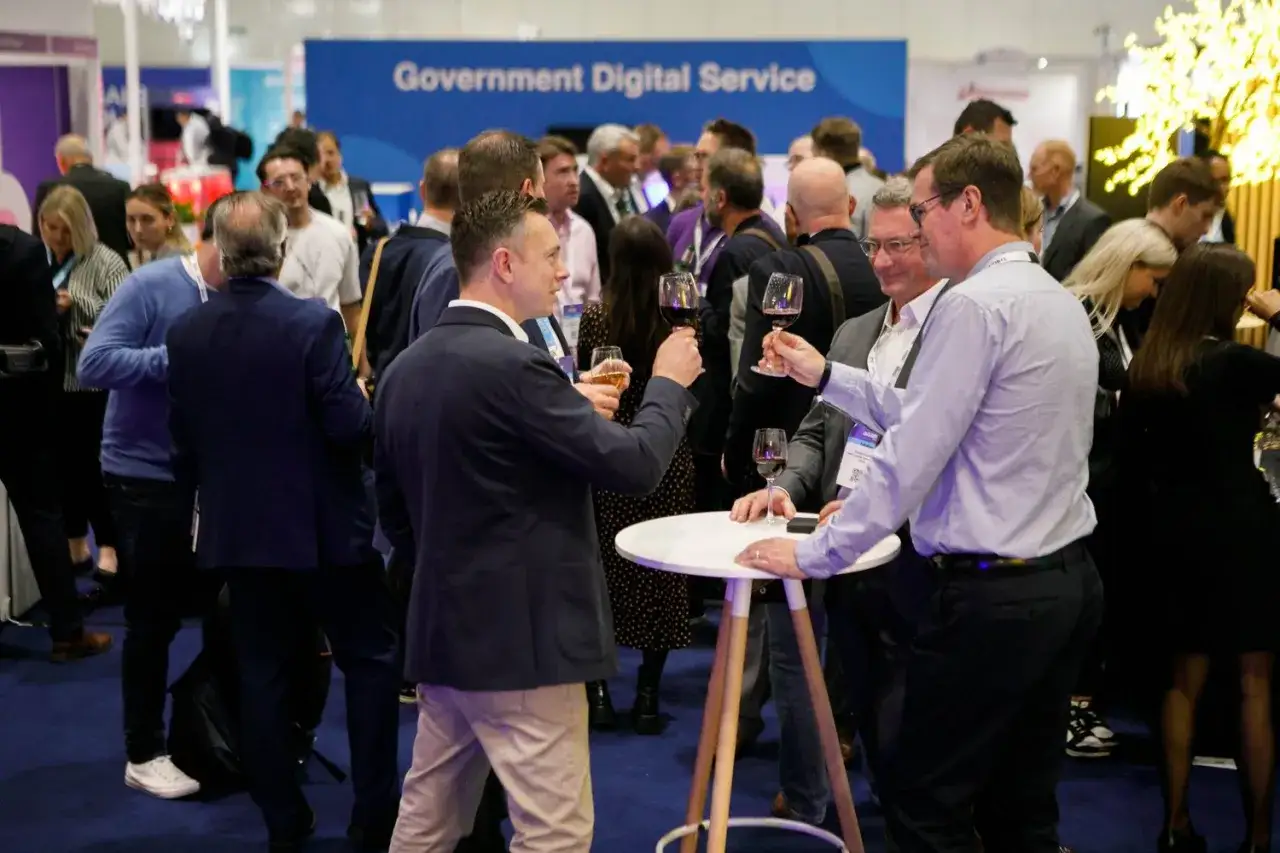 Attendees mingle at government trade shows, enjoying drinks and networking. A 