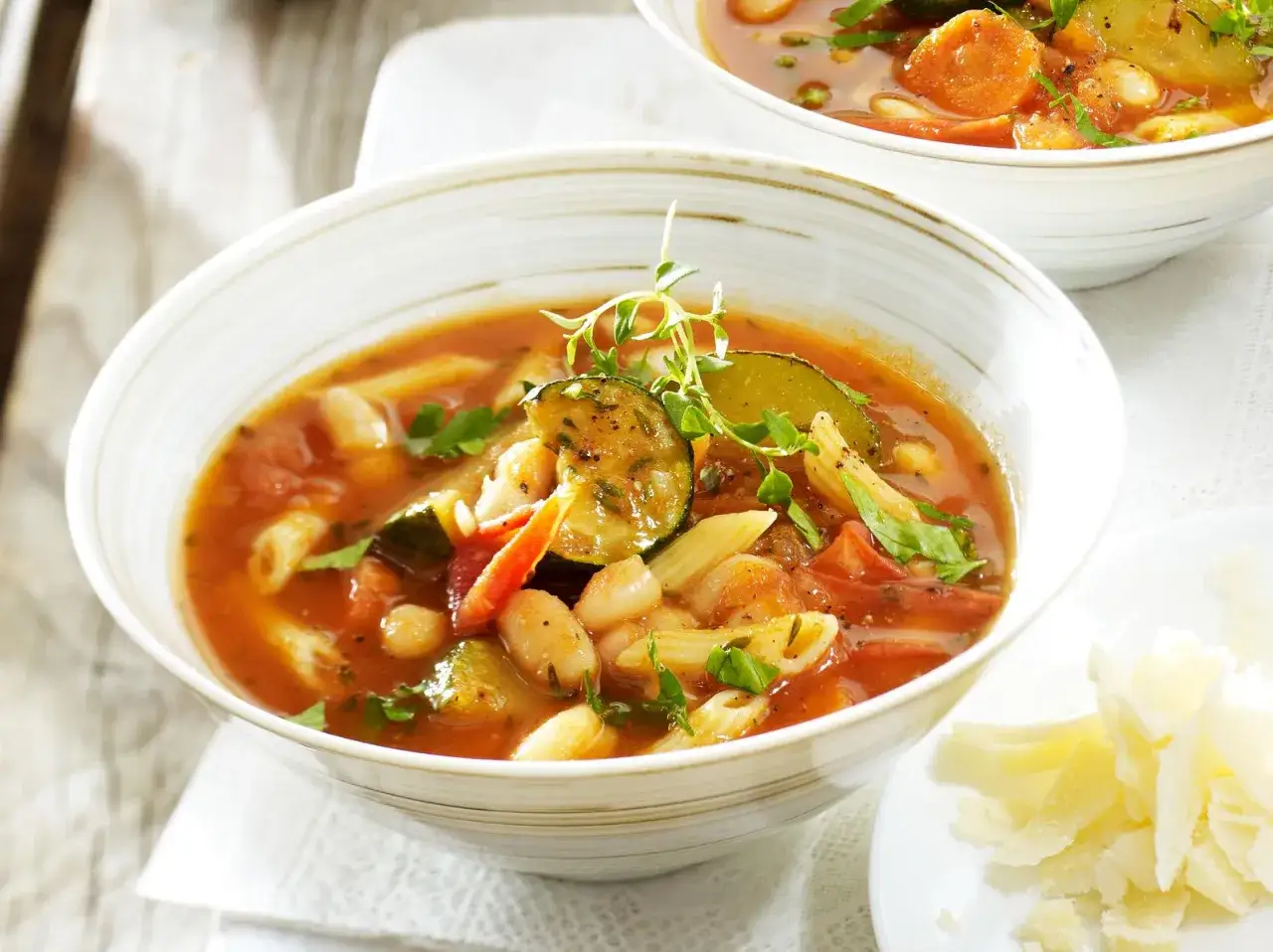 Herzhaftes Minestrone Rezept mit viel Gem&uuml;se, Bohnen und Nudeln, garniert mit frischen Kr&auml;utern.