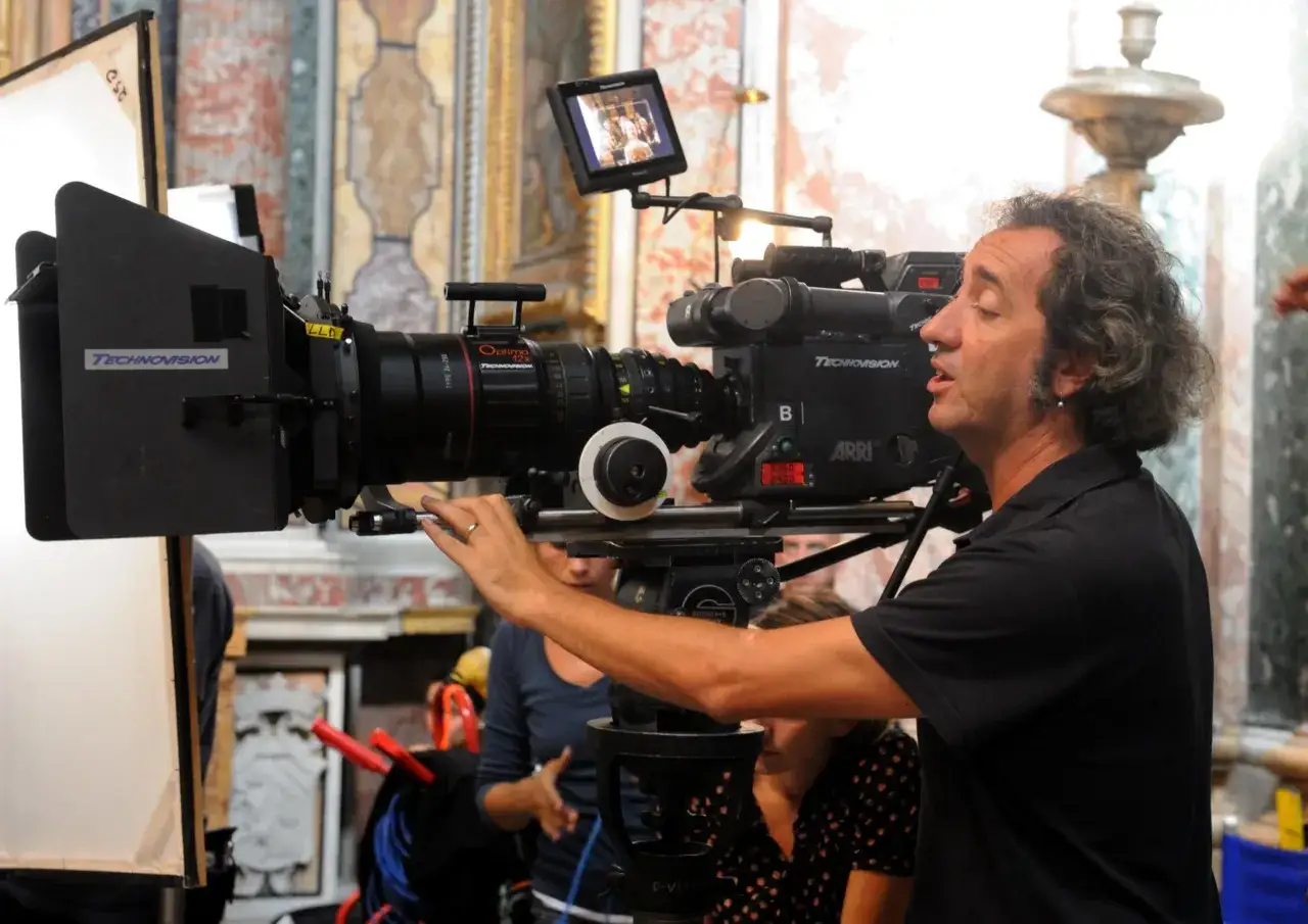 Regista con cinepresa professionale, un'immagine che cattura l'essenza del **film d'autore significato**, tra tecnica e visione artistica.