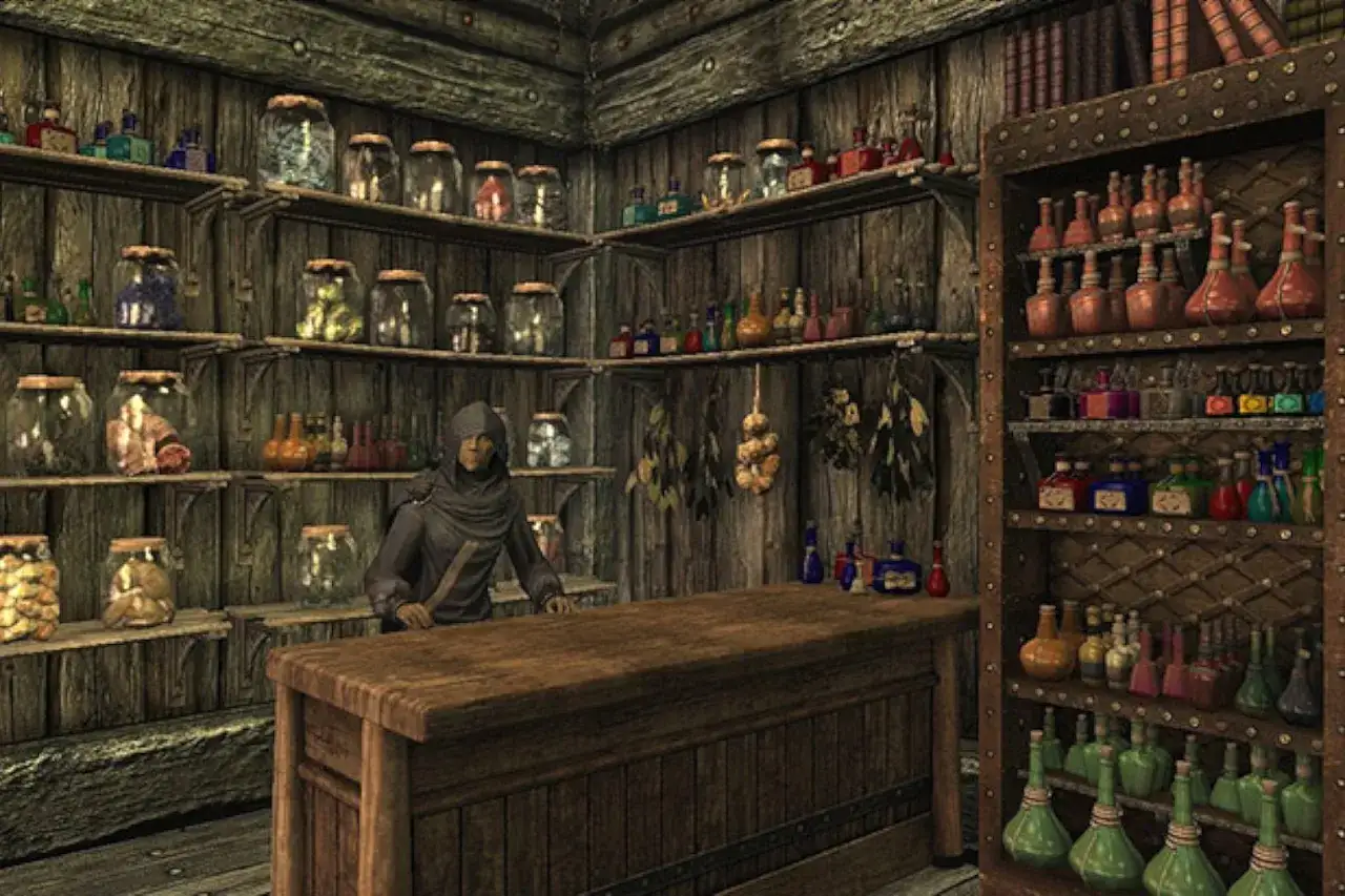 Postać w kapturze za ladą sklepu alchemicznego w Skyrim. Półki uginają się od słoików z ziołami i buteleczek z eliksirami, idealnych do tworzenia własnych **skyrim alchemia przepisy**.