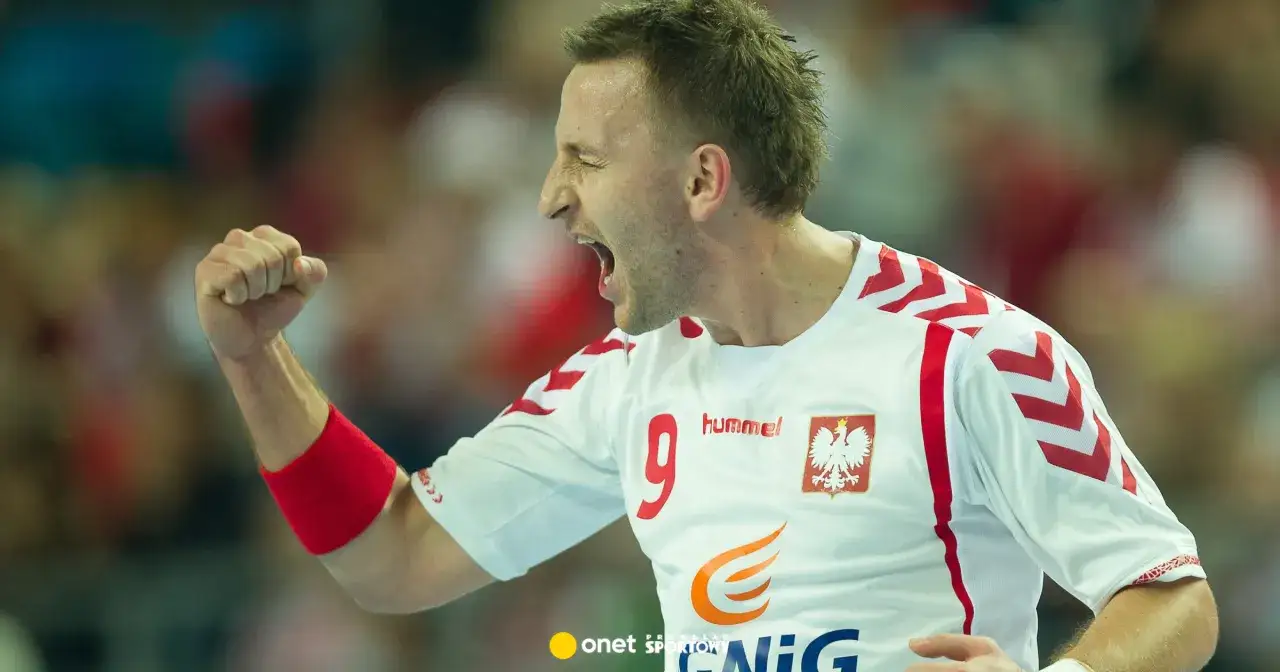 Piłkarz ręczny Michał Bartczak w białej koszulce z orłem i numerem 9, zaciśniętą pięścią w geście triumfu.