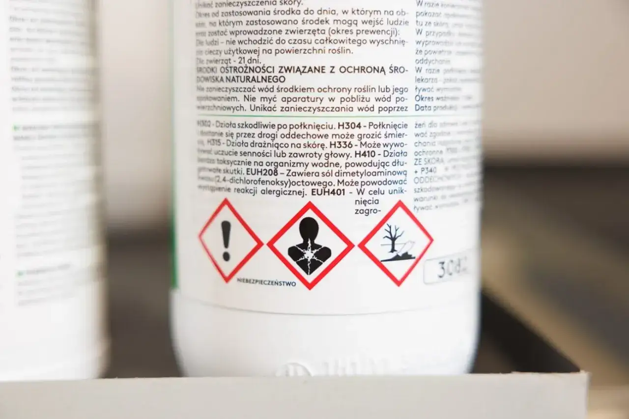 Na etykiecie produktu widnieją piktogramy ostrzegawcze, m.in. symbol zagrożenia dla zdrowia i środowiska. W tekście wspomniano o okresie karencji, czyli czasie od zastosowania środka do dnia, w którym mogą wejść ludzie i zwierzęta.