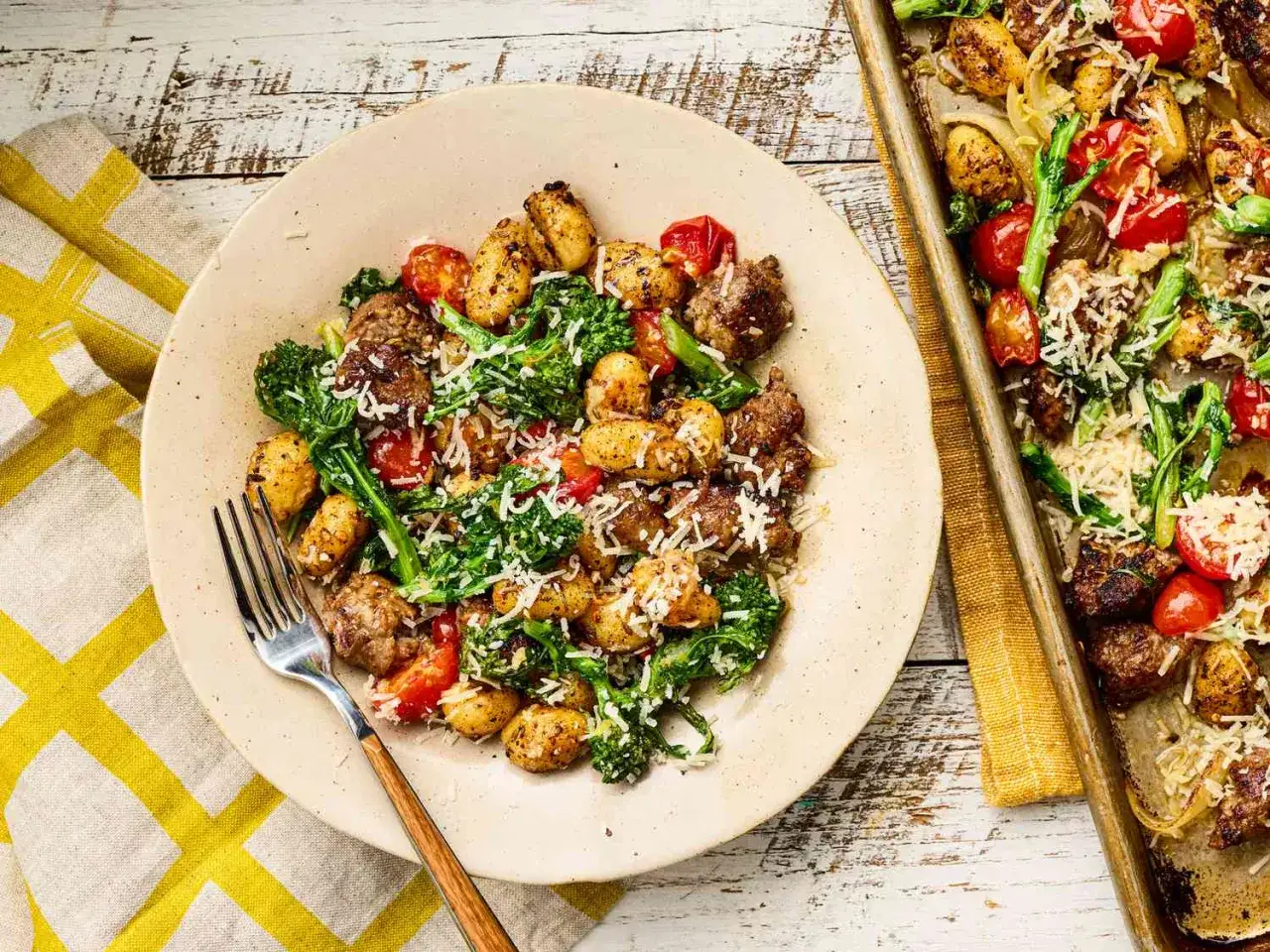Leichte Sommergerichte: Gnocchi mit Brokkoli, Kirschtomaten und Wurst, bestreut mit Parmesan. Ein köstliches Gericht vom Blech.
