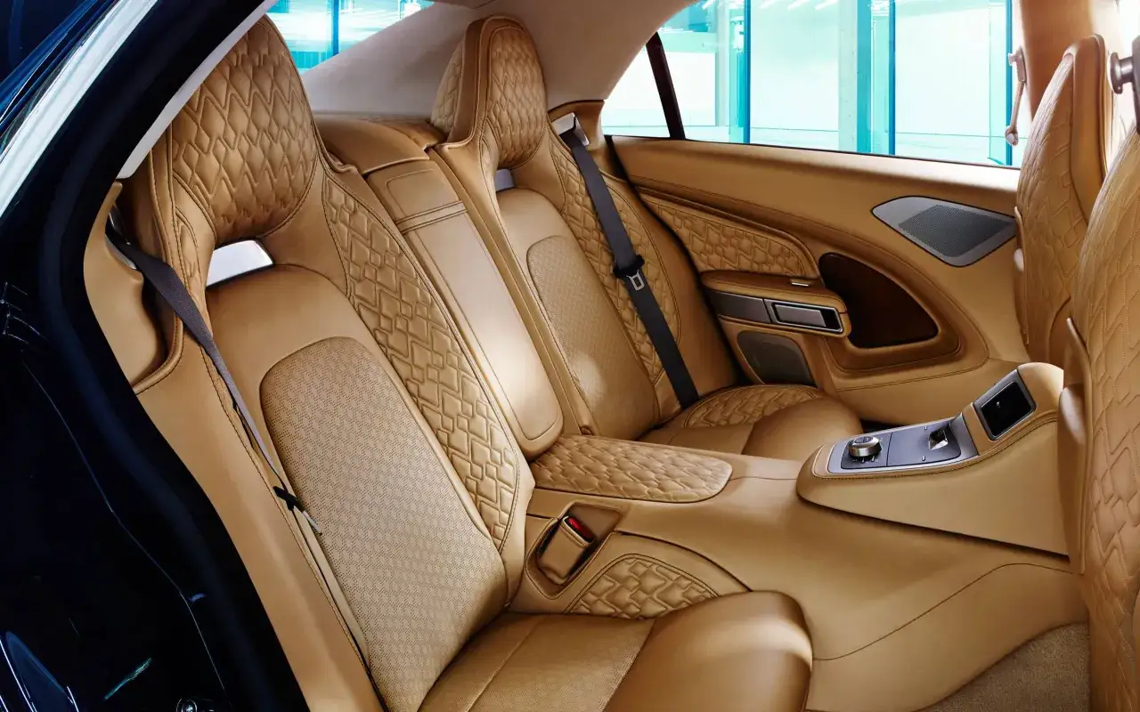 Luksusowe, pikowane skórzane fotele w kolorze karmelowym w Aston Martin Lagonda. Wnętrze emanuje elegancją i komfortem.
