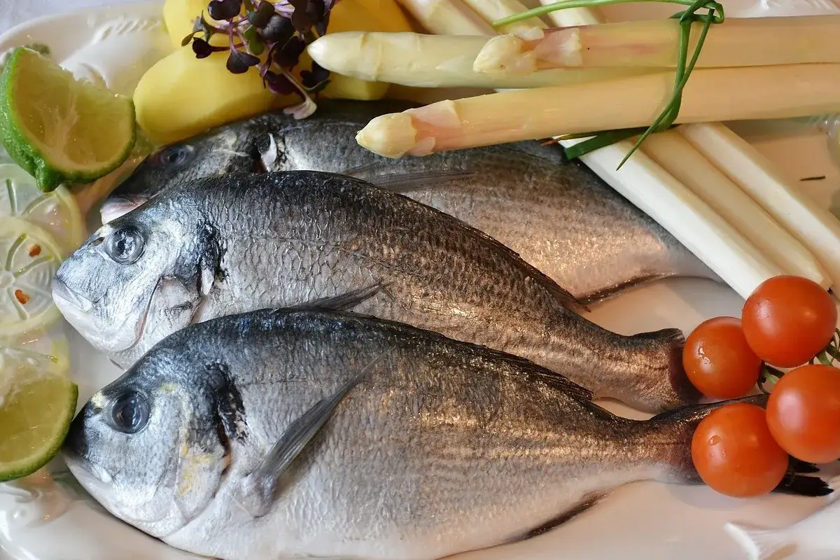 Świeże ryby, ziemniaki, szparagi, pomidorki i limonka – idealne przyprawy do ryby smażonej.