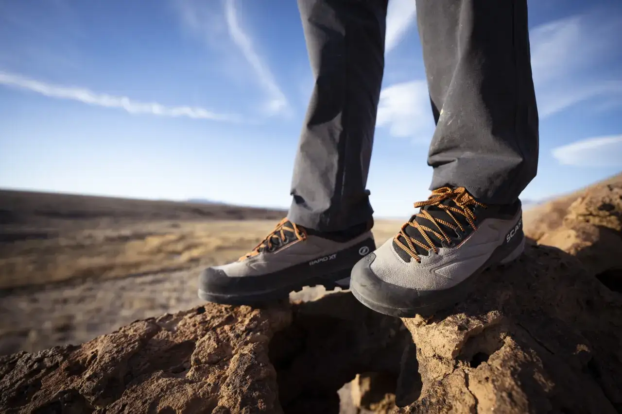 Close-up of approach shoes on rocky terrain, ready for adventure. These shoes offer a blend of grip and support, perfect for scrambling and hiking.