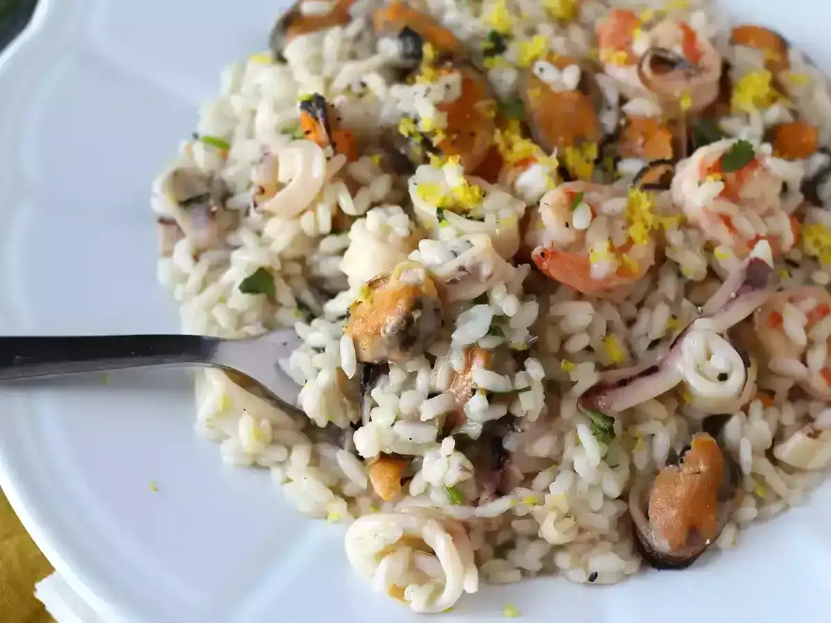 Un d&eacute;licieux risotto fruits de mer cr&eacute;meux, garni de crevettes, moules et calamars, avec une touche de zeste de citron.