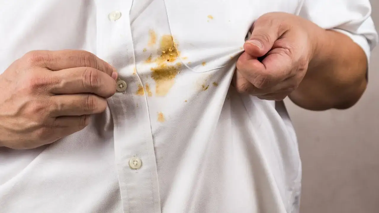 H&auml;nde zeigen ein wei&szlig;es Hemd mit hartn&auml;ckigen curry flecken entfernen.