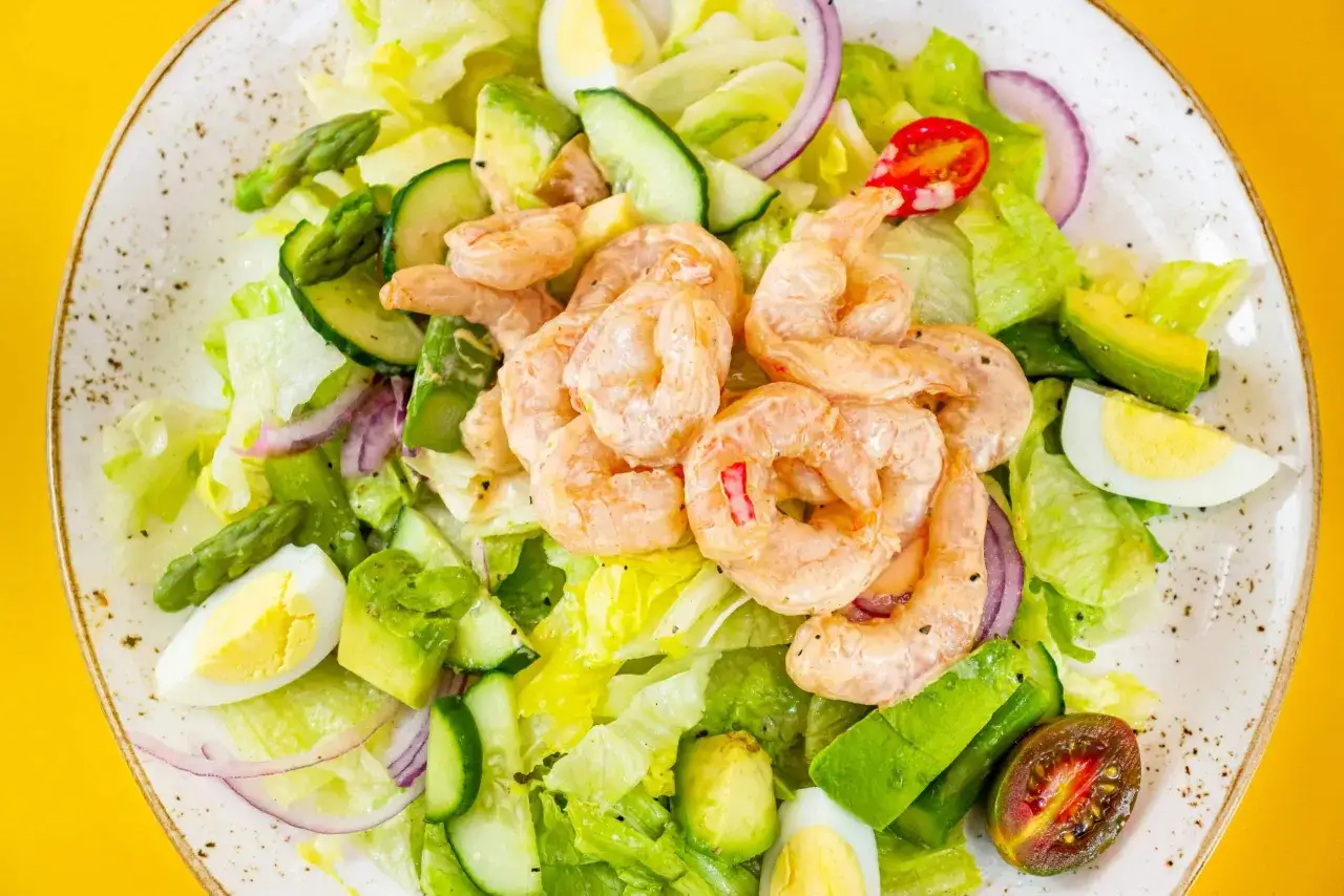 Insalata fresca con gamberi, avocado, uova sode, cetrioli e asparagi. Un'ottima idea su cosa mangiare a Madrid per un pasto leggero e gustoso.