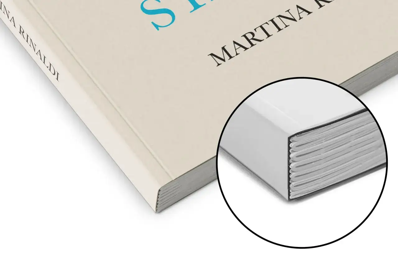 Gros plan sur un livre relié, prêt à imprimer son roman. La tranche des pages est visible, montrant la qualité de la reliure.