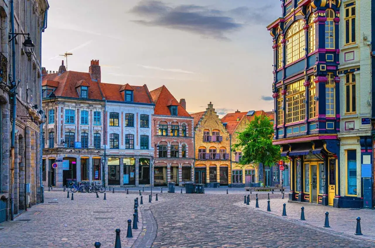 Une rue pavée bordée de maisons colorées et anciennes. Idéal pour savoir que faire à Lille, flâner et admirer l'architecture.