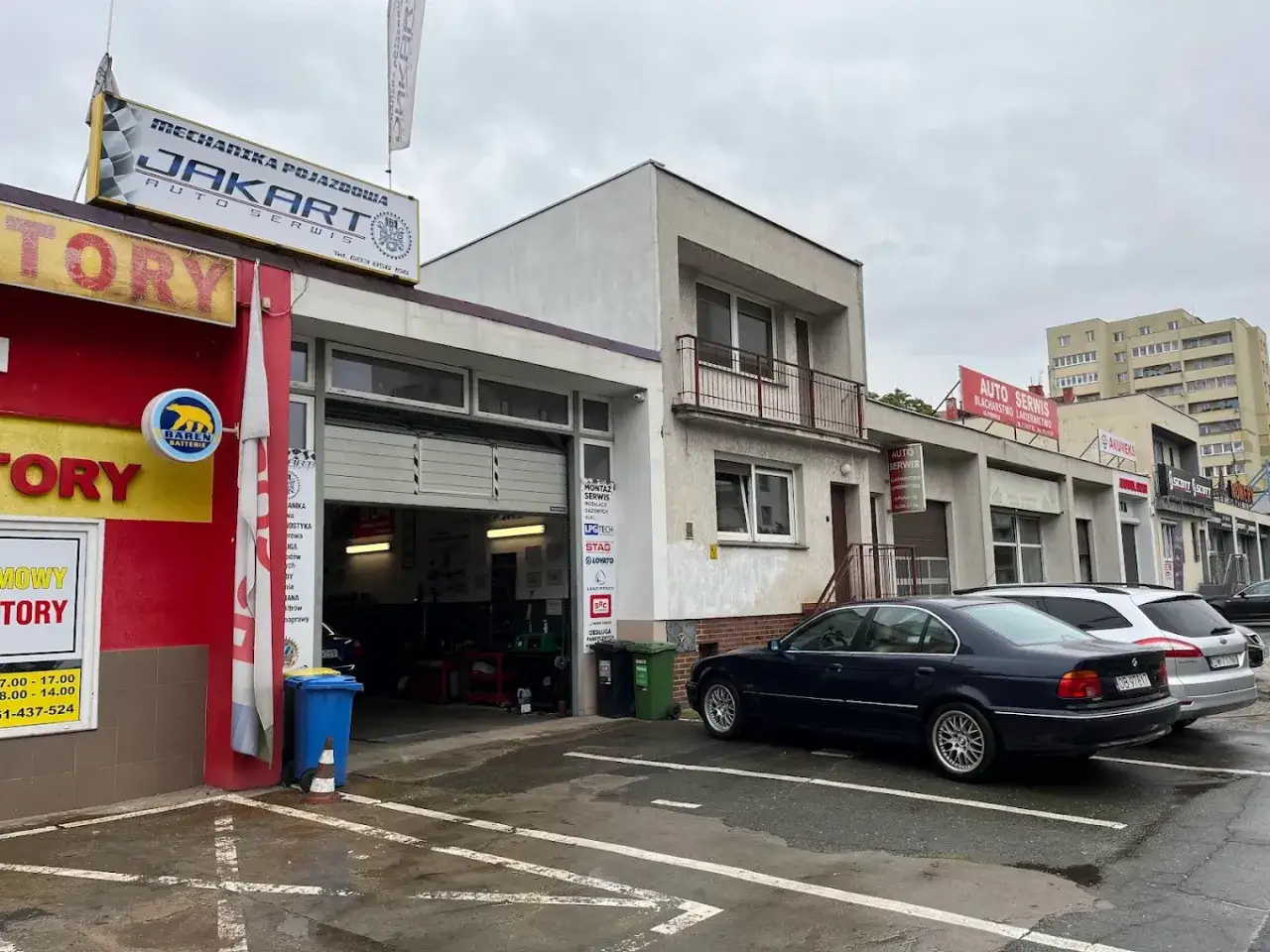Warsztat samochodowy JAKART Auto Serwis. Ciemny sedan czeka na szarpanie na gazie, by zn&oacute;w sprawnie jeździć.